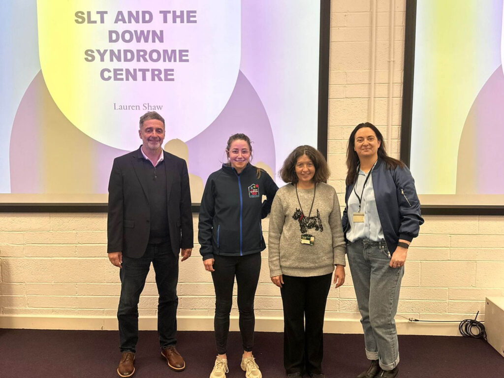 An image of Dr John Greaney, Lauren Shaw, Hannah Barton & Dr Irene Connolly in front of a screen in a lecture theatre.