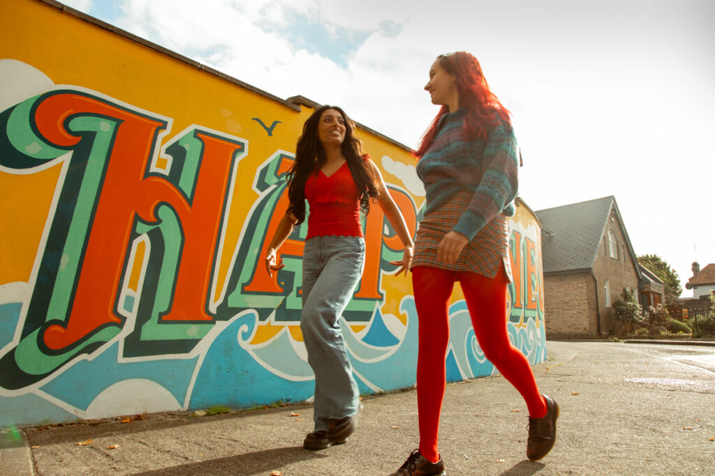 Students walking by mural