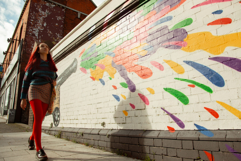 Student walking by mural